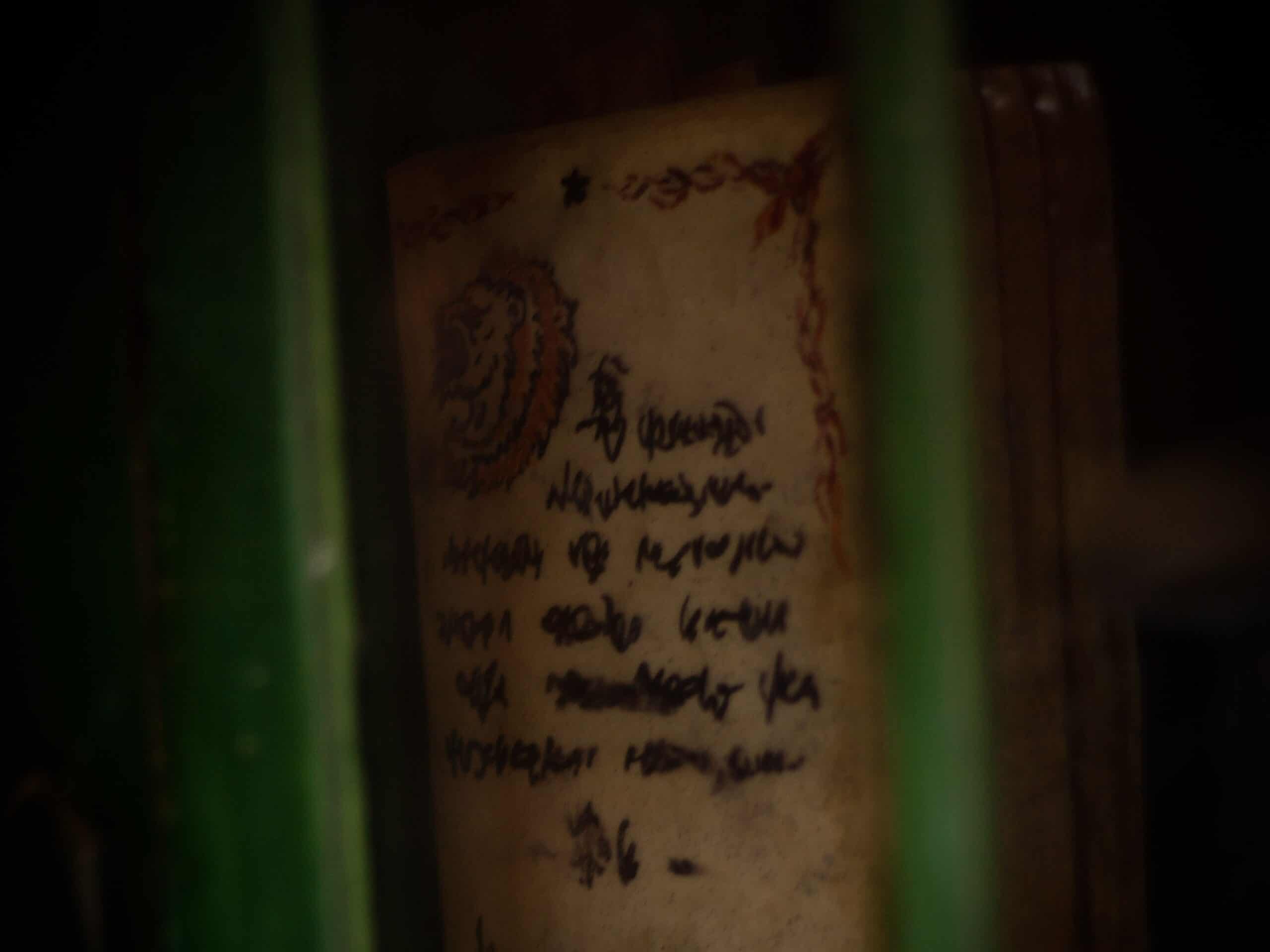 Faintly visible mysterious handwritten note behind green bars, part of an escape room adventure in Bern.